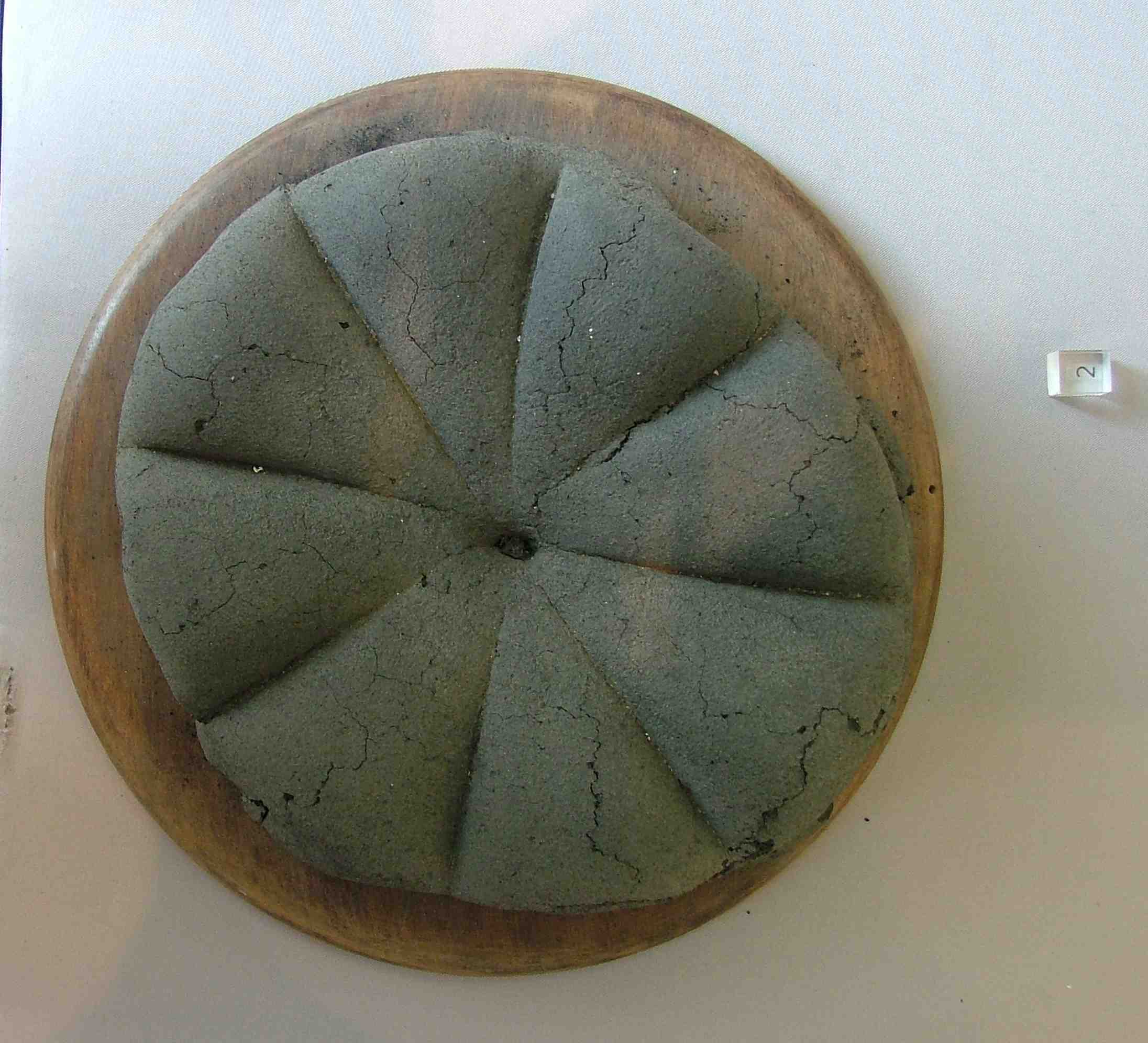 Carbonised Roman bread loaf preserved in Pompeii with eight radial cuts used to divide portions